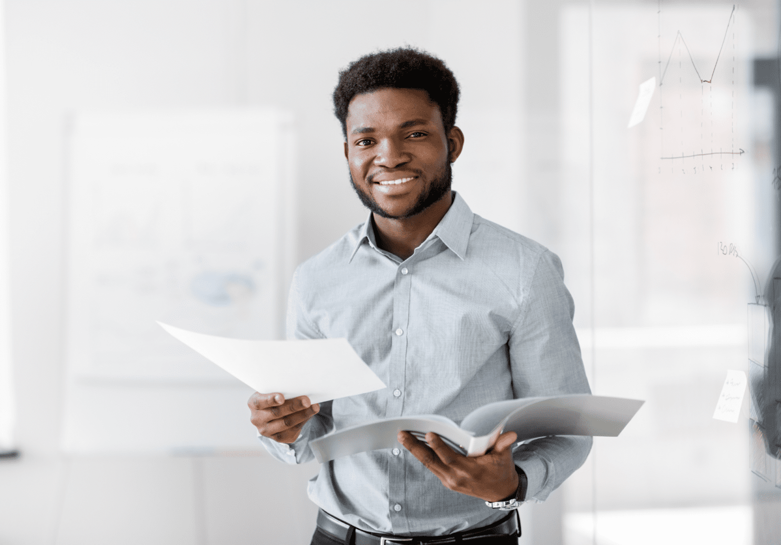 A man holding papers and smiling for the camera.