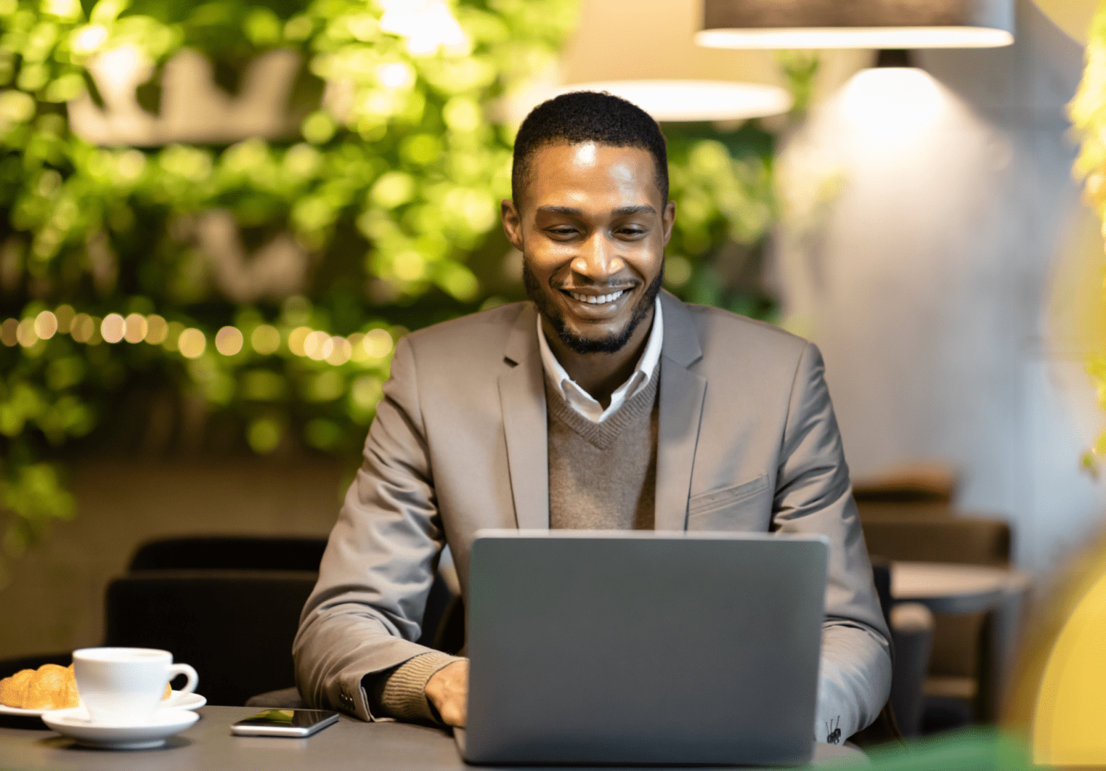 A man sitting at a table with a laptop.