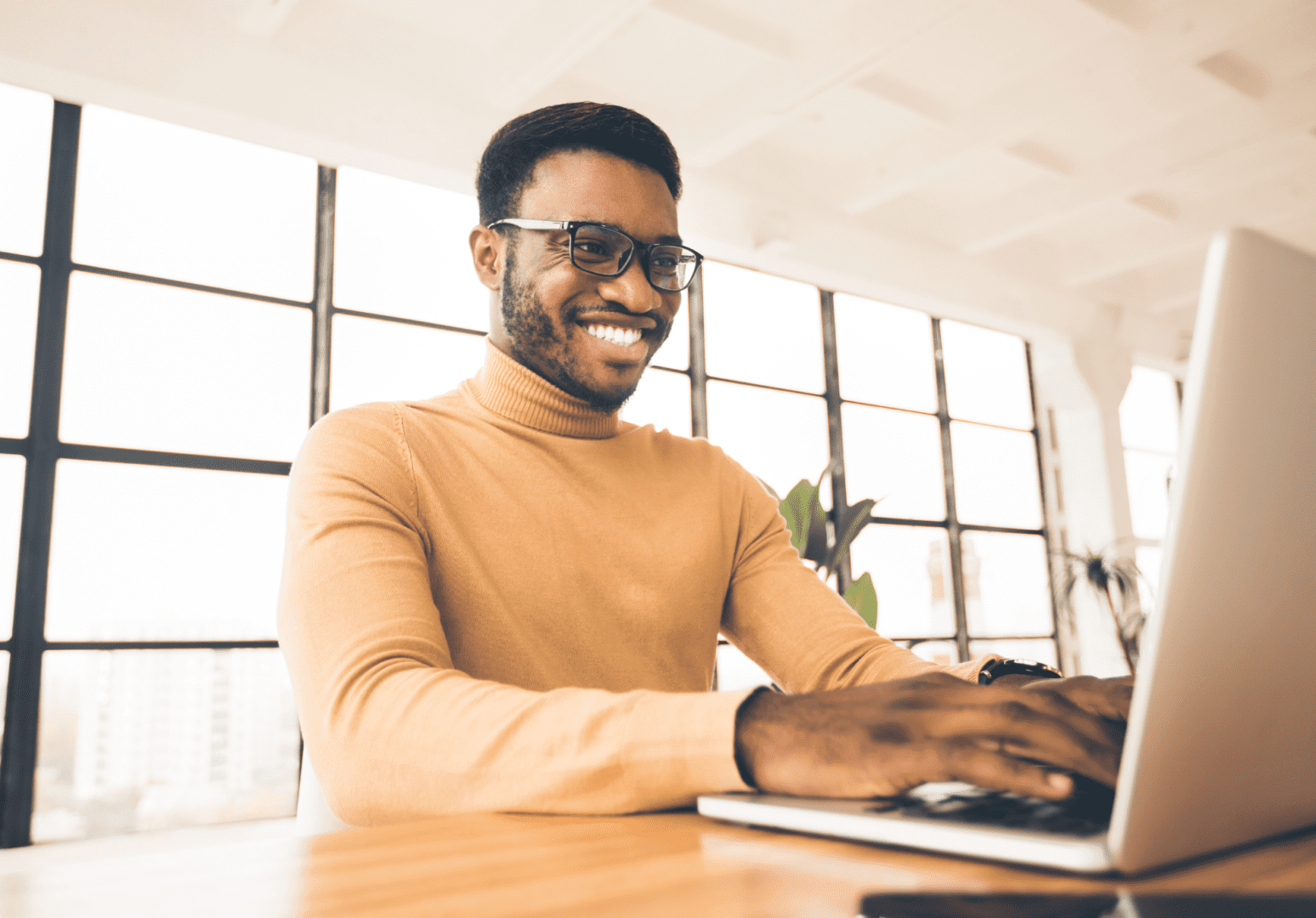 A man sitting at a table with a laptop.