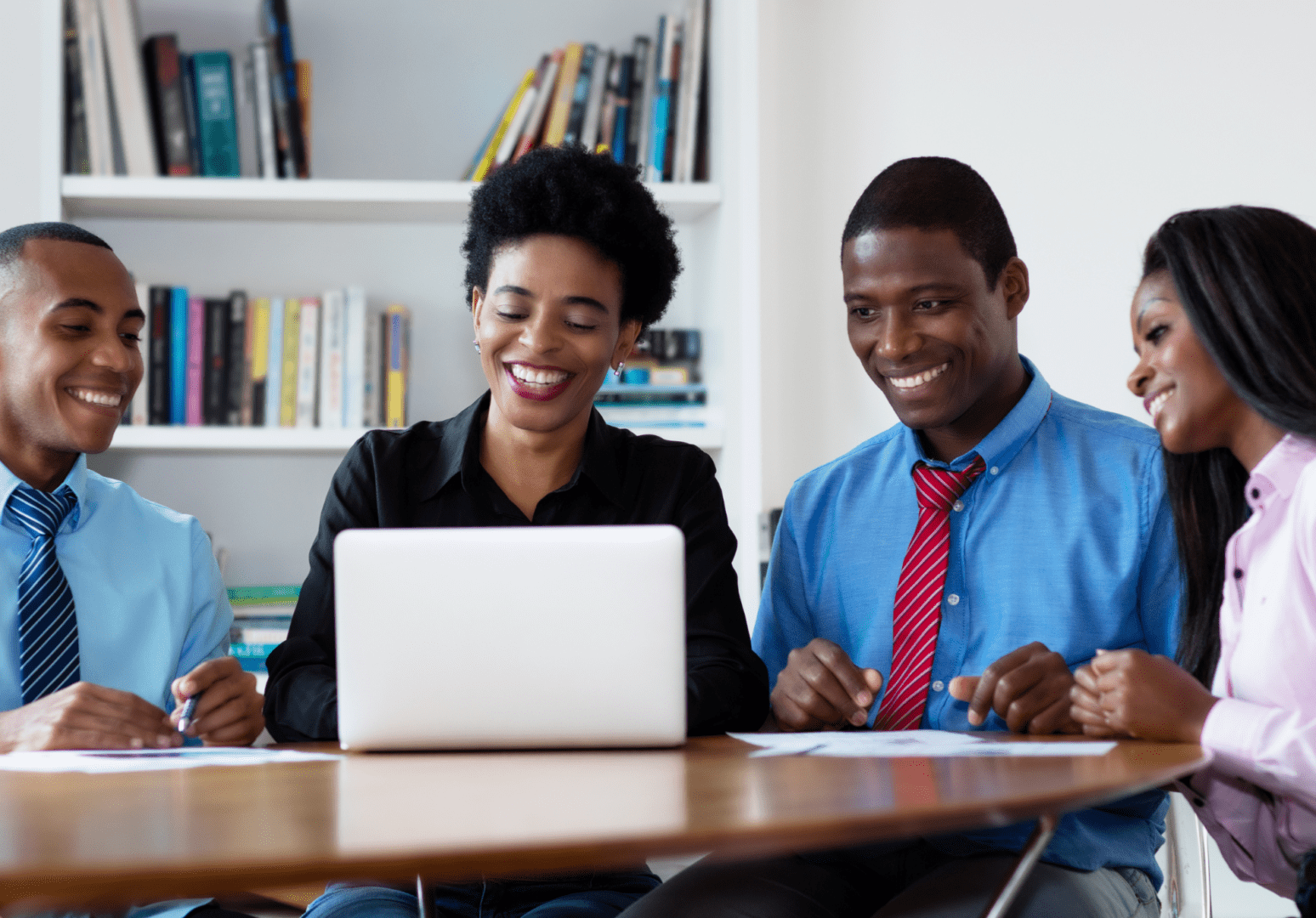 Two people sitting at a table with a laptop